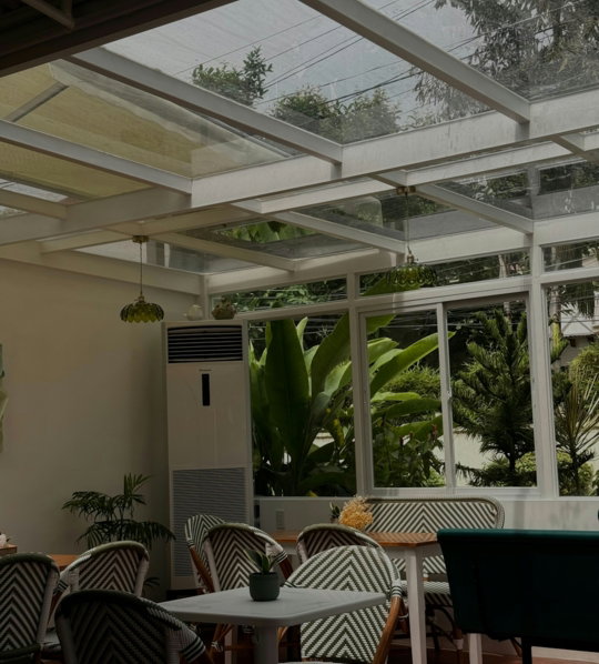 Cafe interior with glass ceiling and lush green plants